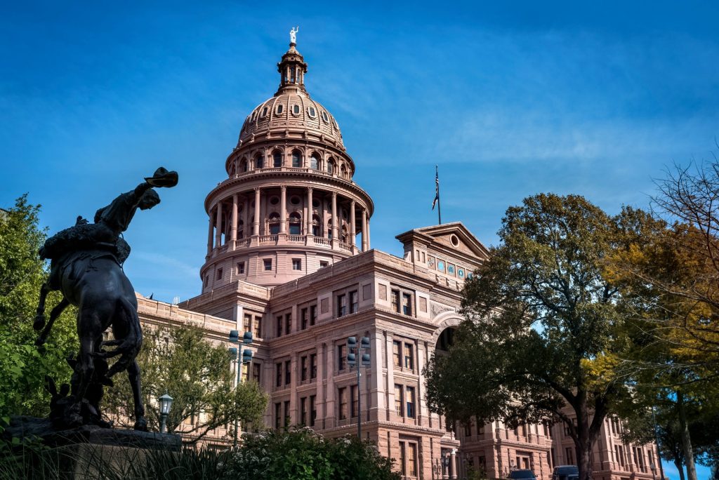 a statue of a man riding a horse in front of a building